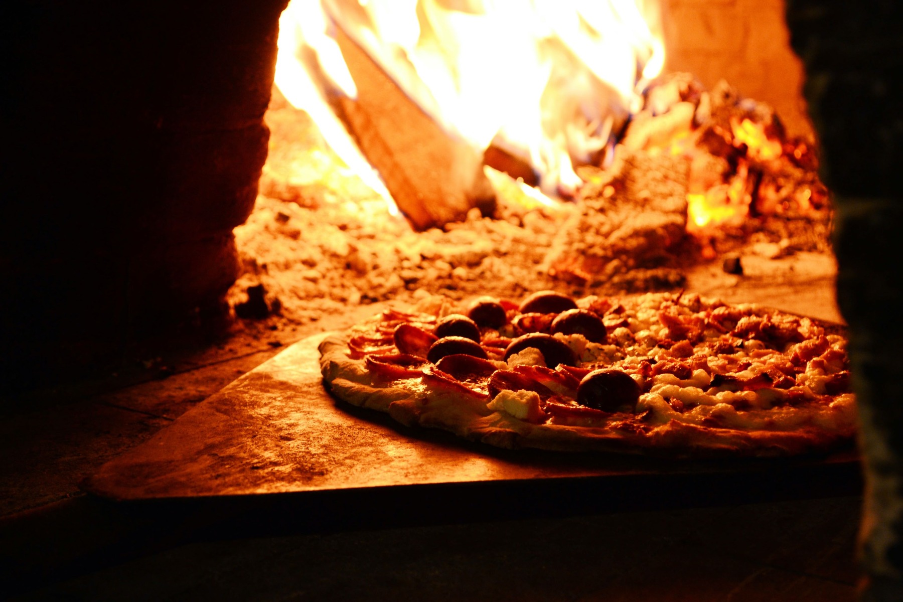 steking av pizza i en vedfyrt ovn